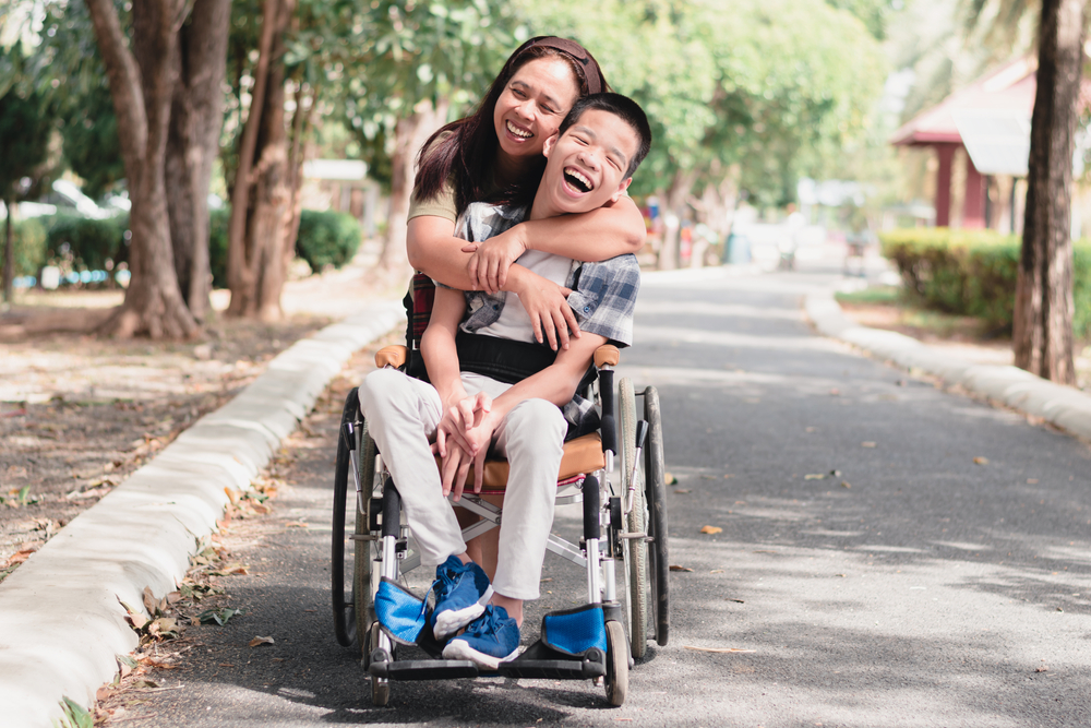 Mother and Asian child with disabilities enjoying therapeutic benefits through animal interactions in an outdoor city park